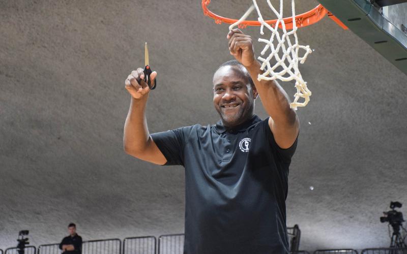 FGC head coach Charles Ruise cuts down a piece of the net after the Timberwolves defeated Pasco-Hernando State College to win the Region 8 championship on Saturday at the Howard Center. (COURTESY)