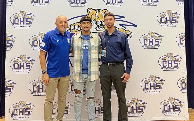 Trinity Baptist coach Dan Robertson (left) stands with Noel Caballero and Caballero’s travel soccer coach Jared Albury during Thursday’s signing ceremony. (COURTESY)