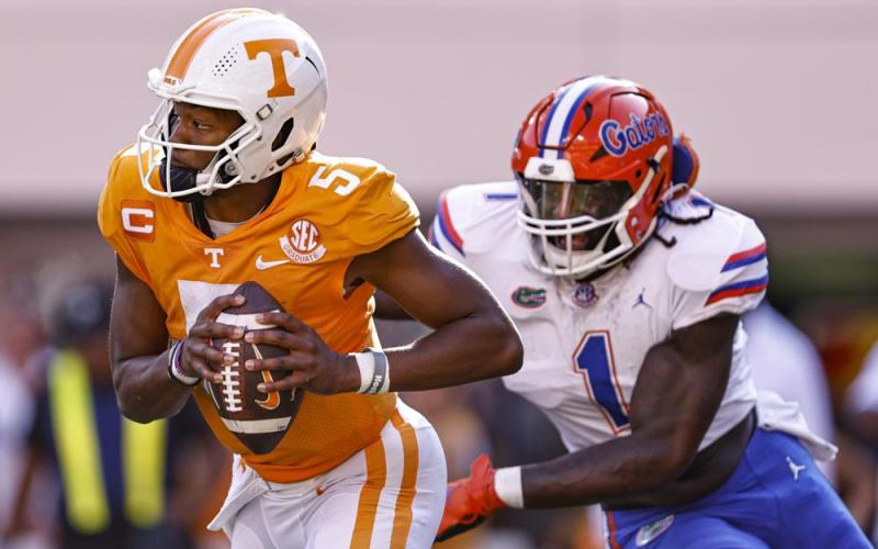 Tennessee quarterback Hendon Hooker runs for yardage while pursued by Florida linebacker Brenton Cox Jr. during Saturday’s game in Knoxville, Tenn.  (WADE PAYNE/Associated Press)