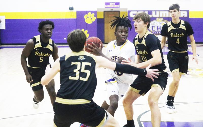 Columbia guard Isaac Broxey drives to the basket as Buchholz forwards Anthony Wilkie (20) and Palmer Walton (35) defend during the District 3-6A quarterfinals on Feb. 8. (FILE)