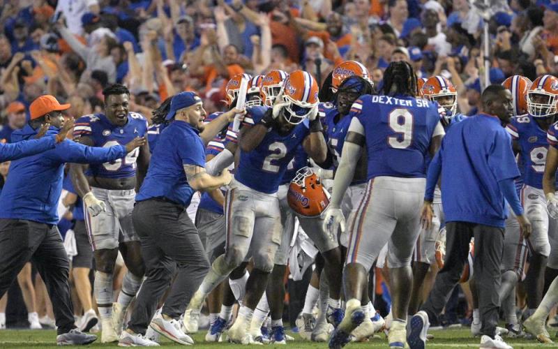 Florida linebacker Amari Burney (2) is swarmed by teammates on the sideline after making a game-saving interception in the end zone near the end of Saturday's game against Utah in Gainesville. (PHELAN M. EBENHACK/Associated Press)