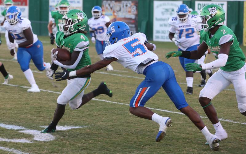 Suwannee running back Marquavious Owens runs past Taylor County safety Da’Varin Mccoy on Monday. (PAUL BUCHANAN/Special to the Reporter)