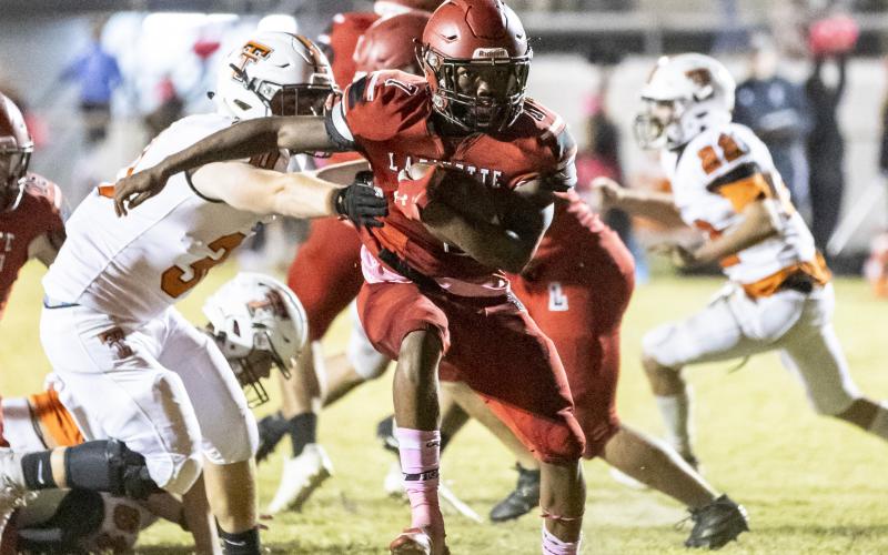 Lafayette running back Kiami McKnight run past a Trenton tackler last Friday. (JACK HOWDESHELL/Special to the Reporter)