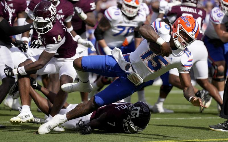 Florida quarterback Anthony Richardson dives past Texas A&M defensive back Jacoby Mathews for a touchdown on Saturday in College Station, Texas. (SAM CRAFT/Associated Press)