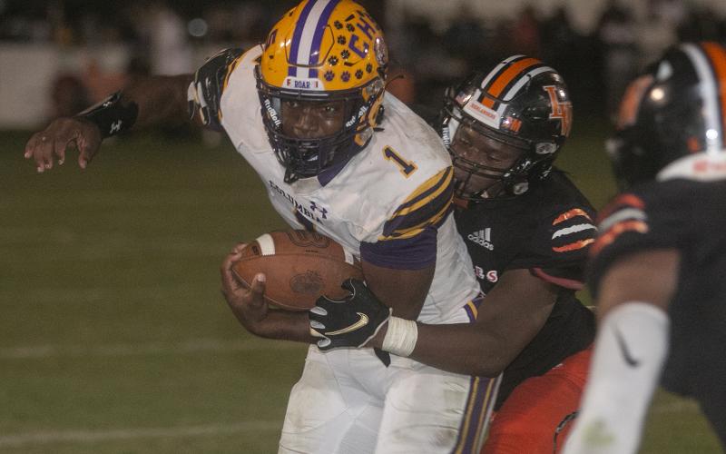 Columbia quarterback Tyler Jefferson tries to pull away from a Lake Wales defender Friday night in a Class 3S state semifinal at Legion Field. (MICHAEL WILSON/Special to the Reporter)