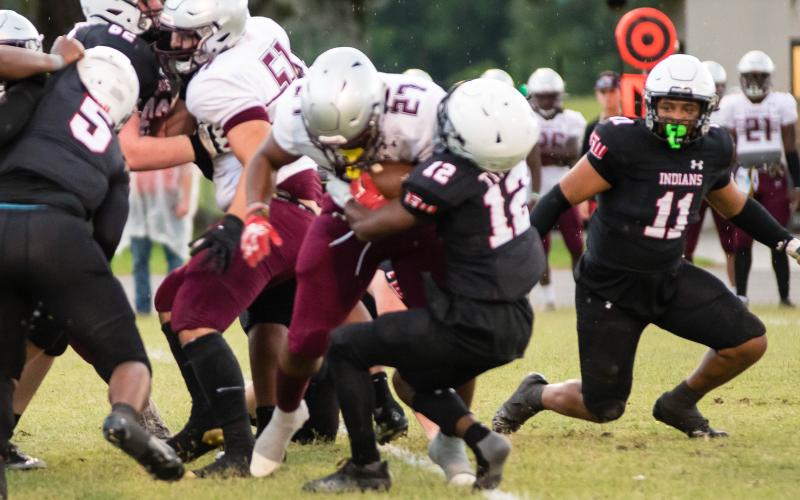 Fort White defensive back Najeeb Smith tackles Madison County running back Jason McDaniel as linebacker Lecosta Byrd rushes in during Tuesday’s spring game. (CHRISTINA FEAGIN/Special to the Reporter)