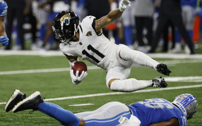 Jacksonville Jaguars wide receiver Parker Washington falls over Detroit Lions defensive end Isaiah Buggs during Saturday's preseason game in Detroit. (DUANE BURLESON/Associated Press)