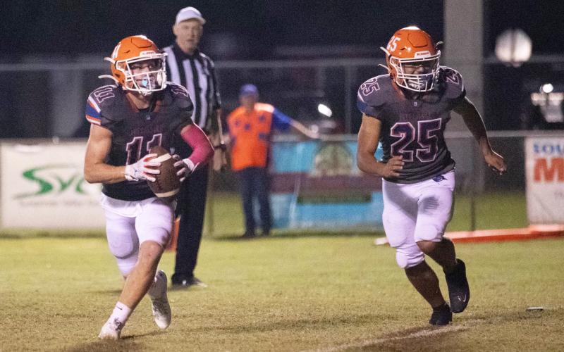 Branford receiver Austin Malaguti runs up the field with the ball alongside kicker Hector Velasquez during last Friday’s game against Hollis Christian Academy. (ERIN ROBERTS/Special to the Reporter)