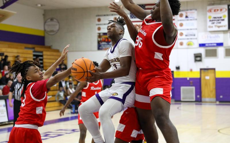 Columbia guard Zamarion Jones tries to get off a shot while being defended by Santa Fe guard Camden Mcleod (3) and forward Jamarion Foye (35) on Friday night. (BRENT KUYKENDALL/Lake City Reporter)