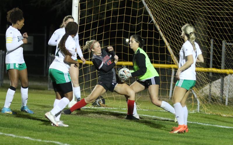 Suwannee goalie Layla Merola stops a shot just as Santa Fe’s Amelia Whitehurst crashes into the box in the second half of Wednesday’s District 2-4A championship. (MORGAN MCMULLEN/Lake City Reporter)