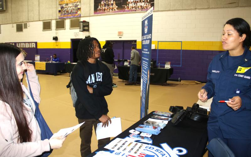 Karyss Butler (from left) and Christopher Hardman, two Columbia High seniors, get recruitment and career tips from Mary Sharpelletti, Chief Petty Officer with the USCG recruiting office in Jacksonville during the Columbia High School College and Career Fair on Thursday. (TONY BRITT/Lake City Reporter)