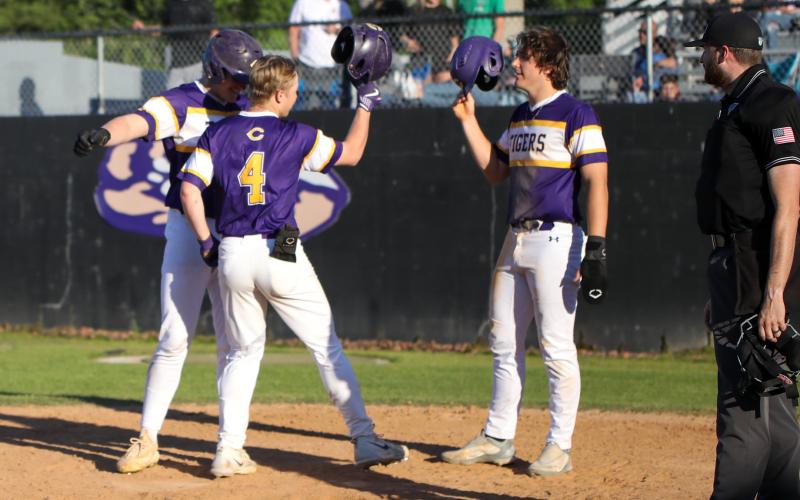 Columbia's Tryace McKenzie is greeted at home plate by teammates Max Schuler (left) and Ayden Phillips after hitting a home run against Bishop Kenny on Friday. (BRENT KUYKENDALL/Lake City Reporter)