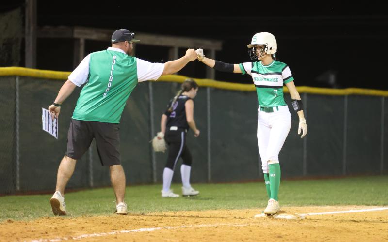 Suwannee head coach Greg Gabey (left) fist bumps Rachel Smith after she reached third base against Gainesville on April 12. (PAUL BUCHANAN/Special to the Reporter)