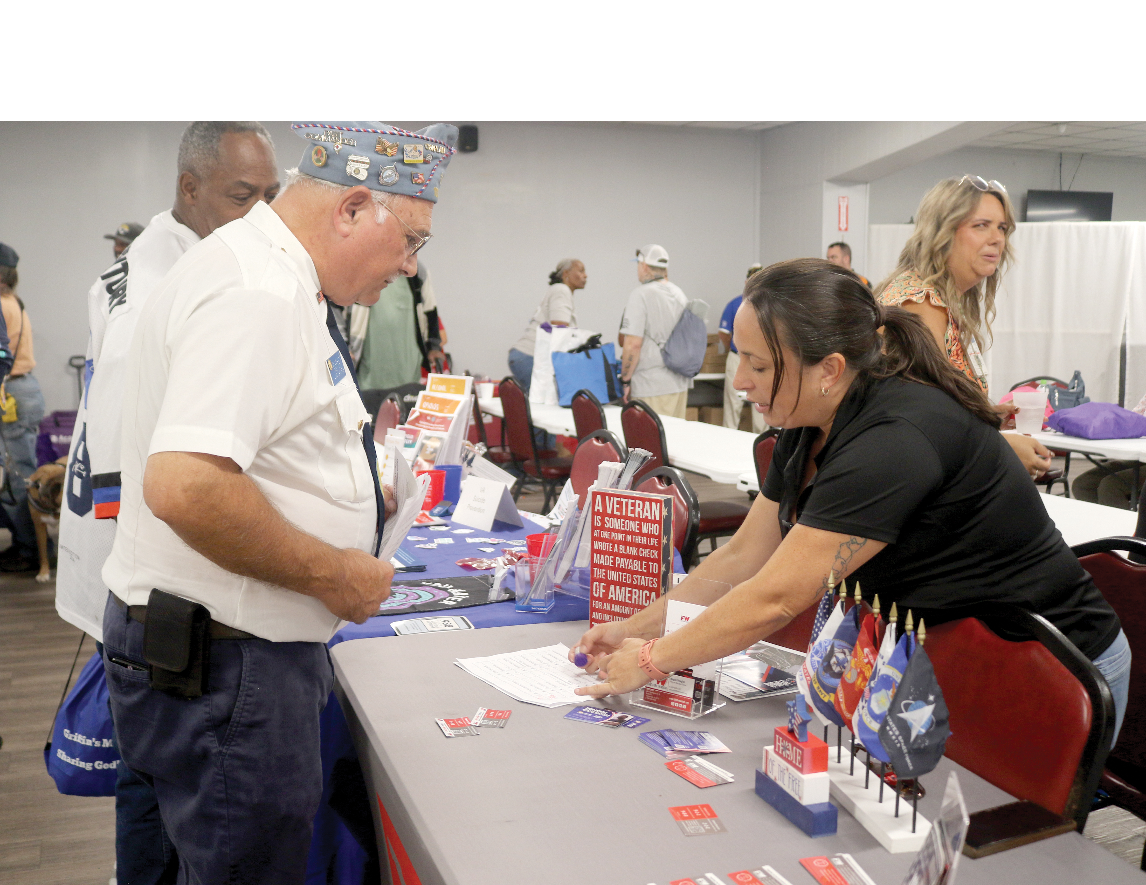 Megan Douglas (right), a representative of The Fire Watch, talks to a veteran during the Veteran Stand Down and Resource Fair at the American Legion Post 57 on Wednesday. (TONY BRITT/Lake City Reporter)