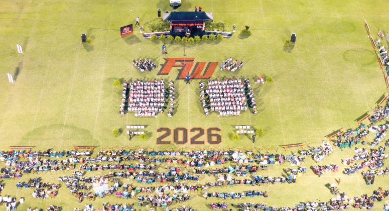 Family and friends surround the graduates on the field at Arrowhead Stadium on Friday night as Fort White High held its commencement ceremony for the Class of 2026. The ceremony was interrupted for about 45 minutes due to lightning in the area. (RAY CARPENTER/Lake City Reporter)