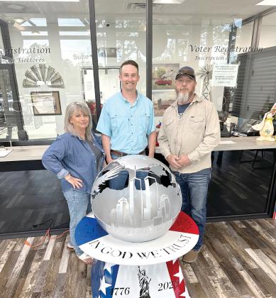 Rhonda Anderson (from left) stands with Kent Banner, Columbia County Assistant Supervisor of Elections, and Darryl Thomas, Columbia High School welding instructor, as the school’s welding piece, ‘Globe of Freedom,’ is on display at the Columbia County Supervisor of Elections Office. (COURTESY)