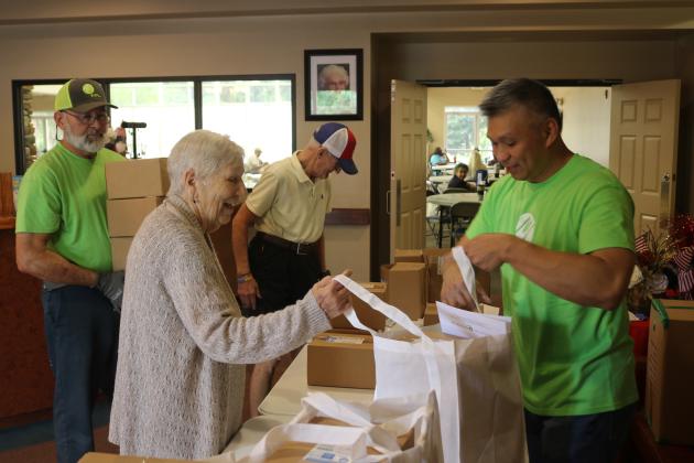Donna Kite (left) is aided by FPL employee Chi Lui as she gets a bag of hurricane meals while at the Lifestyle Enrichment Center on Wednesday afternoon. FPL provided bags for 153 seniors during the session. (TONY BRITT/Lake City Reporter)