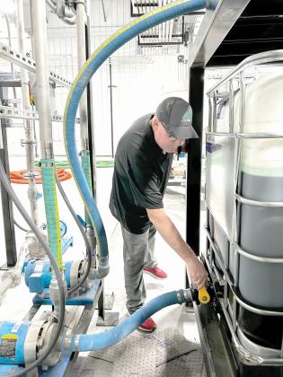 AgroLiquid site manager Jeff Herald prepares ingredients inside the Lake City facility. (COURTESY AGROLIQUID)