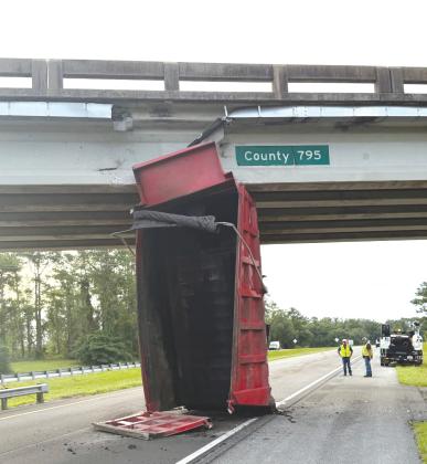 A dump truck’s bed sits in the eastbound lanes of Interstate 10 after hitting the County Road 795 overpass on Monday. (COURTESY FHP)