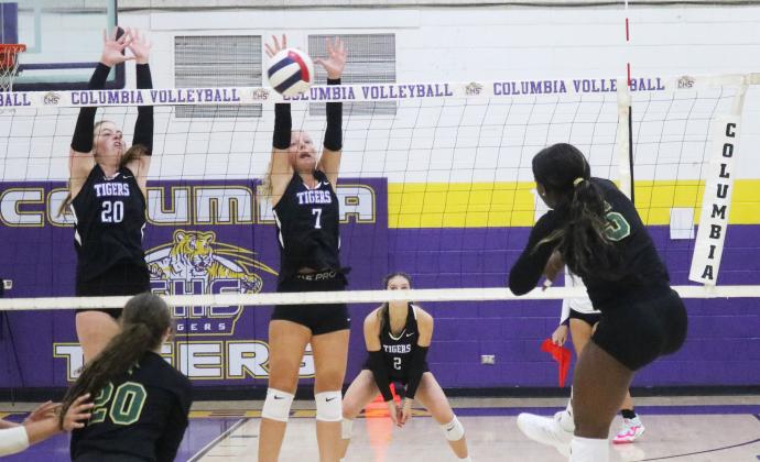Lincoln outside hitter Jaci Dickens fires a shot towards Columbia hitter Langsley Smith (20) and Addison Jones (7) on Thursday. (JORDAN KROEGER/Lake City Reporter)