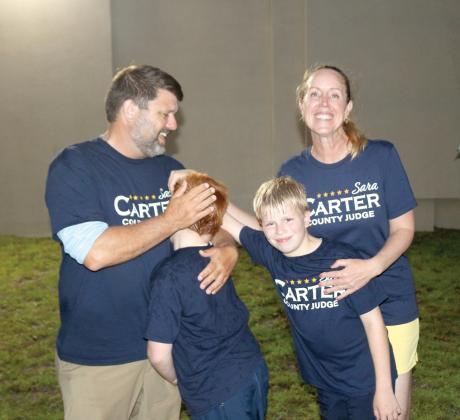 Sara Carter celebrates with her husband, Travis, and sons, Jack (left) and George after winning re-election as Columbia County judge on Tuesday night. (TONY BRITT/Lake City Reporter)