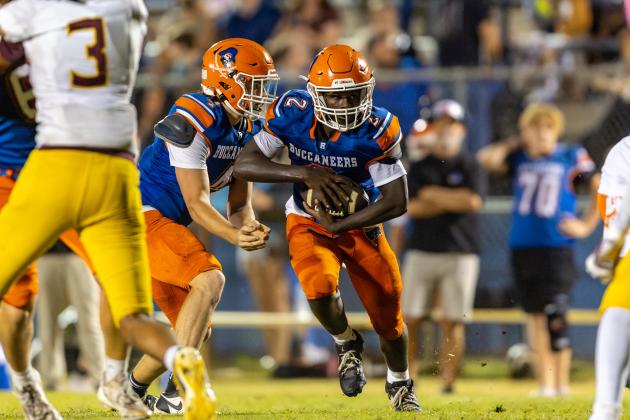 Branford quarterback Trent Land hands the ball off the running back Ollie James on Friday. (JACK HOWDESHELL/Lake City Reporter)