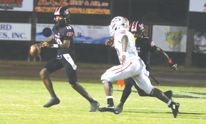 Fort White quarterback Chance Johnson rolls out to avoid pressure from Santa Fe last Friday. (MORGAN MCMULLEN/Lake City Reporter)