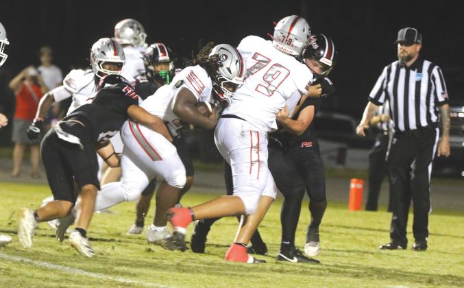 Santa Fe running back Jasiah Powell pulls a Fort White defender with him Friday night. (MORGAN MCMULLEN/Lake City Reporter)