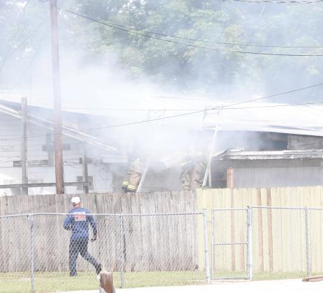 Lake City firefighters combat a fire in an attic space of a house on NW Burk Avenue late Thursday morning. (JAMIE WACHTER/Lake City Reporter)
