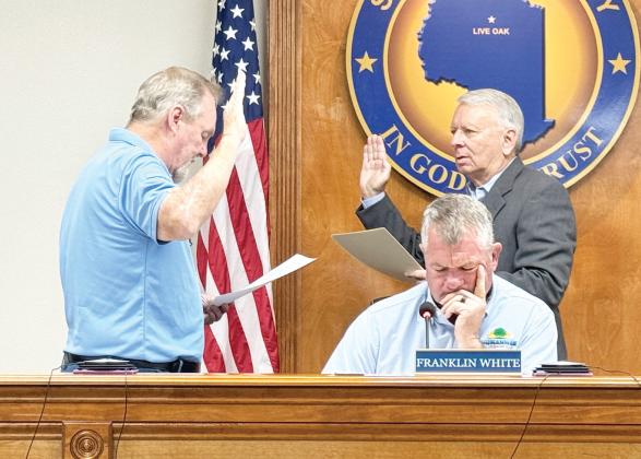 Roger Busscher (left) takes the oath of office to serve on the North Florida Water Utilities Authority board during its meeting Monday. NFWUA Attorney Grady Williams (right) administers the oath. (JAMIE WACHTER/Lake City Reporter)