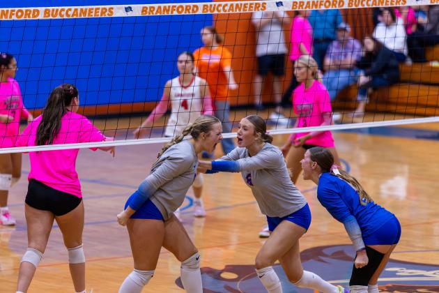 Branford outside hitter Anabella Dicks (left) celebrates her kill with teammates Raelea Bradow (6) and Ava Alcorn (12) during Tuesday's win over Lafayette. (JACK HOWDESHELL/Lake City Reporter)