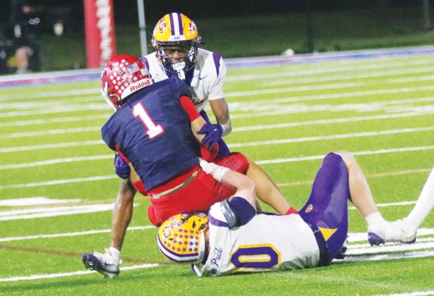 Columbia defensive back Mekah Combs-Turner (back) and linebacker Bryson Grinstead (bottom) combine to tackle Manatee receiver Deno Dalacas on Oct. 2. (JORDAN KROEGER/Lake City Reporter)