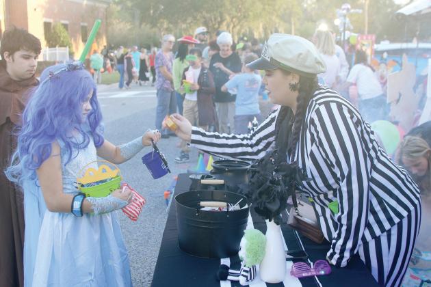 Lyndsey Weissendorn receives candy from Florida Department of Transportation employee Kaitlyn Hill during a previous year’s trunk-or-treat event at the District 2 office. (FILE)