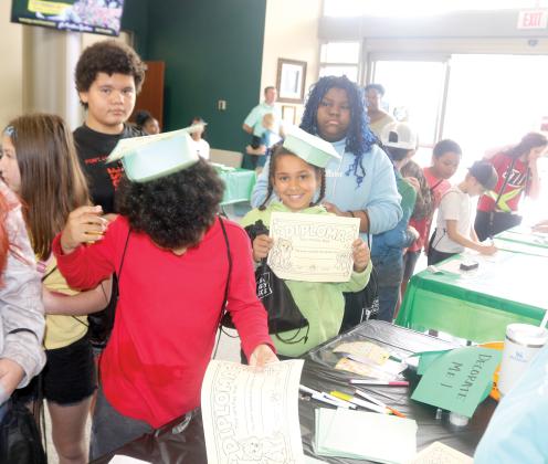 Fort White Elementary School fifth-graders created graduation caps and diplomas while attending an event at the college on Friday morning. (TONY BRITT/Lake City Reporter)