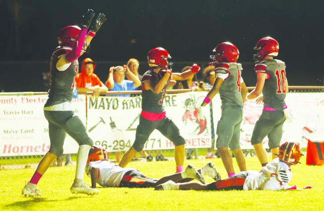 Lafayette defensive back Lane O’Steen (middle) holds the ball after intercepting Trenton’s final pass Friday night at Dale Walker Field as teammates Jack Stewart (from left), Issac Watkins and Tucker Higginbotham celebrate. Trenton receivers Kage Jackson and MJ Gaskins lie on the field in disbelief. (PAUL BUCHANAN/Lake City Reporter)