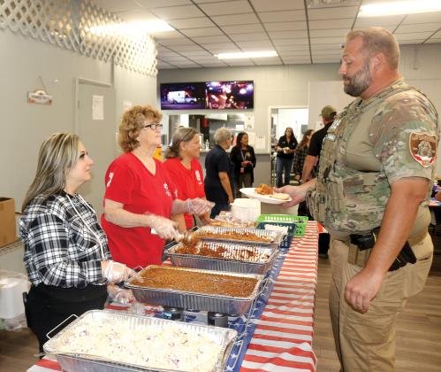 Agriculture Law Enforcement officer Zack Skinner gets a plate of barbecue from American Legion Post 57 volunteers during the post’s First Responder Luncheon on Wednesday. (TONY BRITT/Lake City Reporter)