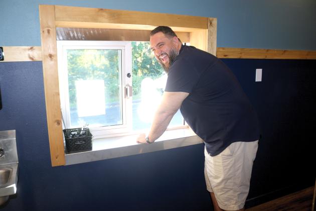 James Crenshaw, proprietor of Phish Tales, laughs as he hands out a meal through the restaurant’s new drive-through window. The restaurant also is adding a cocktail lounge, an inside waiting area and offering up additional dessert options from Amy Strickland. (TONY BRITT/Lake City Reporter)