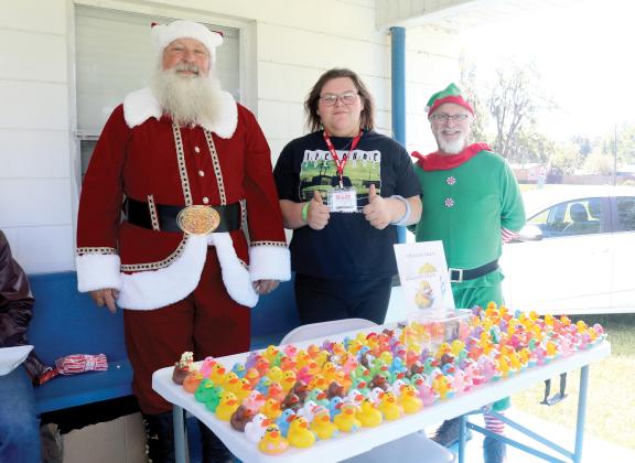 Mike Haney (from left), dressed as Saint Nicholas, stands with Linda Knox and Jim Senzamici during the inaugural charity biker’s ride for the Suwannee County Toys for Tots program. (TONY BRITT/Lake City Reporter)