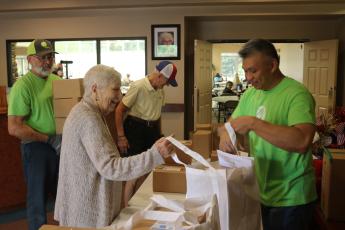 Donna Kite (left) is aided by FPL employee Chi Lui as she gets a bag of hurricane meals while at the Lifestyle Enrichment Center on Wednesday afternoon. FPL provided bags for 153 seniors during the session. (TONY BRITT/Lake City Reporter)