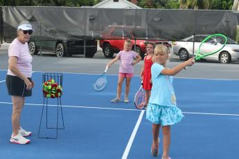 Marcia Kazmierski (left) watches as Jensen Haire, 8, hits a tennis ball during the 10th annual James Montgomery Tennis Camp at Youngs Park on Thursday. (TONY BRITT/Lake City Reporter)