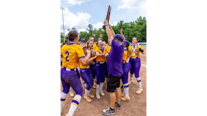 Columbia’s softball team celebrates as head coach Joe Saucier raises the Class 4A state championship trophy after the Tigers defeated Lake Wales on May 23. (JACK HOWDESHELL/Lake City Reporter)