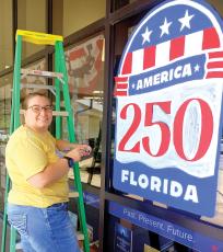 Artist Maggie Wilburn finishes up her America 250 art work on the Suwannee River Regional Library’s Live Oak branch ahead of the July 4 holiday. (ROB WOLFE/Lake City Reporter)