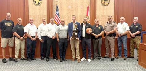 Columbia County Clerk of Court Jay Swisher holds the Boots and Badges championship trophy ahead of this year’s tournament. The Legal Eagles, representing attorneys at the courthouse, are the defending champions. (COURTESY)