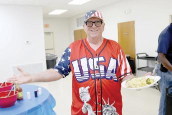 Layne Schultetus, clad in an American jersey, was all smiles with a plate full of the chicken perlau dinner ahead of Thursday’s Columbia County GOP candidate rally at the Westside Community Center. (TONY BRITT/Lake City Reporter)