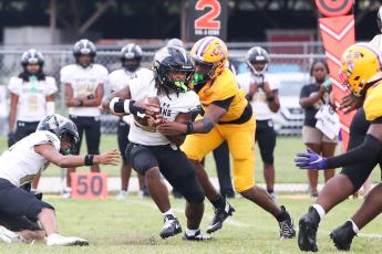 Columbia defensive end Mikel Morgan tackles Lakewood running back Amir Smith in the backfield on Friday. (BRENT KUYKENDALL/Lake City Reporter)
