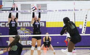 Lincoln outside hitter Jaci Dickens fires a shot towards Columbia hitter Langsley Smith (20) and Addison Jones (7) on Thursday. (JORDAN KROEGER/Lake City Reporter)
