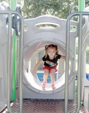 Ellie Davis makes her way through a tunnel on a piece of equipment at Sallie Mae Jerry Park on Friday. (TONY BRITT/Lake City Reporter)