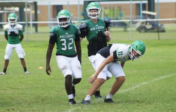 Suwannee quarterback Haigen Johnson (11) rushes a pass after being pressured by linebackers Travis Fead (32) and Kyler Watson during Monday’s practice. (JAMIE WACHTER/Lake City Reporter)