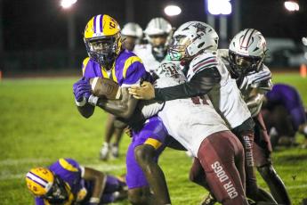 Columbia receiver Kyren Caldwell fights for extra yardage as he’s tackled by a group of Madison County defenders following a catch last Friday. (BRENT KUYKENDALL/Lake City Reporter)