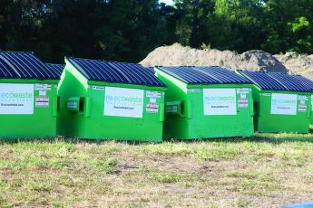 Ecowaste Solutions commercial dumpsters sit in Ellisville waiting to be swapped in for existing Waste Pro cans for customers around the county. Ecowaste takes over as the solid waste collection contractor on Oct. 1. (JAMIE WACHTER/Lake City Reporter)